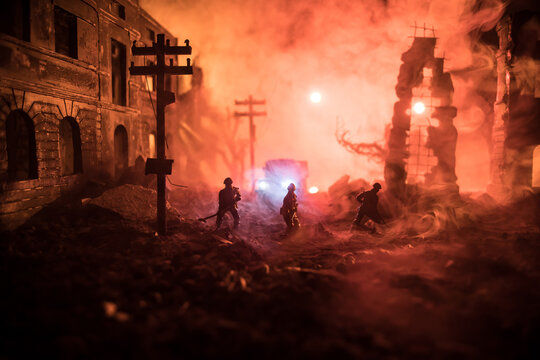 War Concept. Military silhouettes fighting scene on war fog sky background. Sappers clears mines at the site of recent fighting zone. Battle in ruined city.