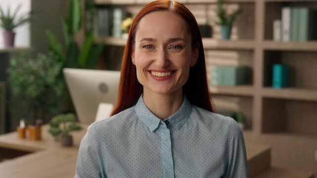 Smiling Caucasian business woman inviting hand in office looking camera happy friendly ginger female manager recruiting welcoming gesture join come here employer worker HR recruiter hiring team indoor