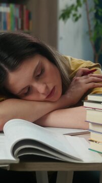 Exhausted Caucasian woman female student sleeping desk books indoor library tired girl teacher napping study preparing exam university academy education overwork fatigue boring lecture studying late