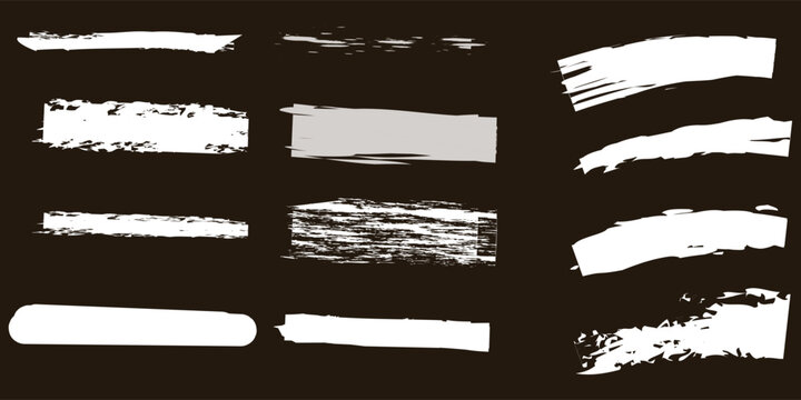 Collection of white acrylic paint brush strokes and chalk smears on dark background