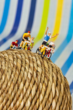 Winning Miniature Cyclists Racing Toward Success on a Woven Sphere symbolizing achievement and competitive leadership