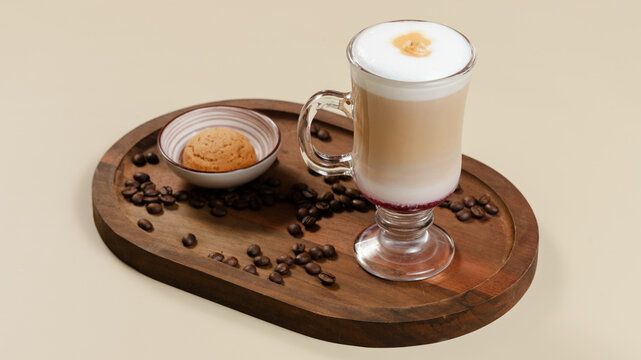 Coffee glass cup on wooden tray with coffee beans and cookie