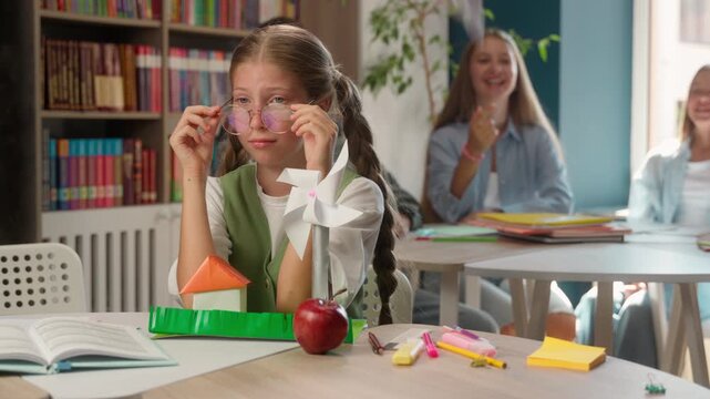 School bullying crying Caucasian girl child suffering in classroom lonely kid classmates teasing mocking throwing paper airplane abuse problem sad student schoolgirl victim education stress depression