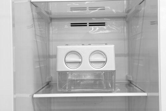 Automatic ice maker unit with clear bin for ice cubes inside domestic refrigerator appliance
