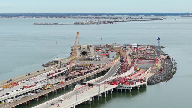 Aerial video of the Hampton Roads Bridge-Tunnel expansion project in Virginia, showing highway bridge construction, heavy cranes, and traffic over the Chesapeake Bay.