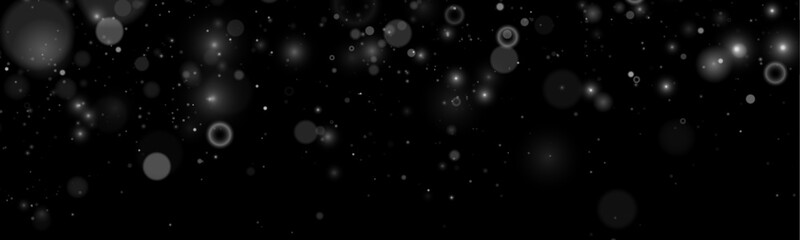 Silver glitter sparkles drift softly on a dark transparent background. Tiny particles shimmer delicately like magical stars. Perfect overlay for holiday and New Year designs. © goldstock