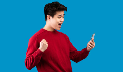 Yes, Big Luck. Portrait Of Excited Asian Guy Celebrating Triumph, Using Mobile Phone, Emotional...