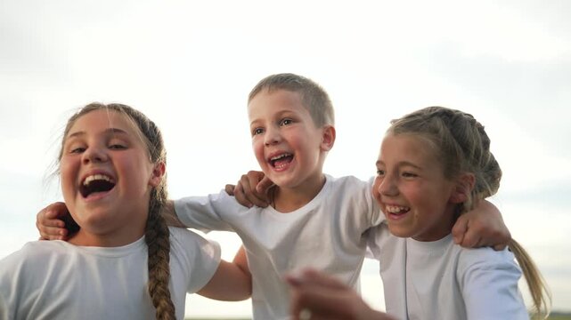 Happy children hugging outdoors. happy children enjoying fun together. Children smiling laughing showcasing friendship. Group kids bonding happy faces full joy. Hugging children having fun outside.