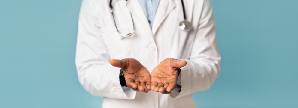Hygiene, virus protection, prevent disease during COVID-19 epidemic. Middle aged african american guy in white coat with stethoscope shows clean hands, isolated on blue background, panorama, cropped