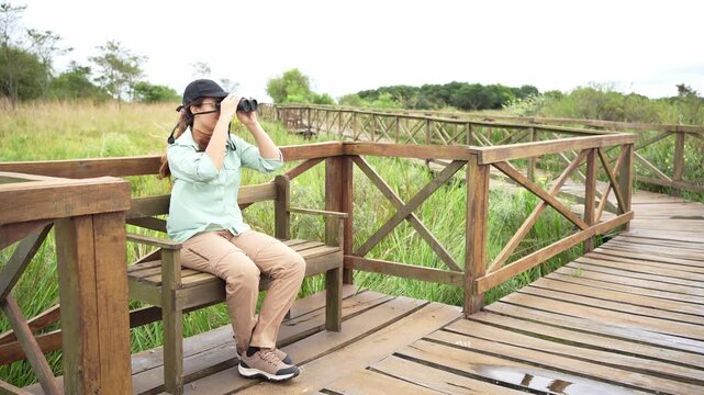 Female birder watching birds with binoculars