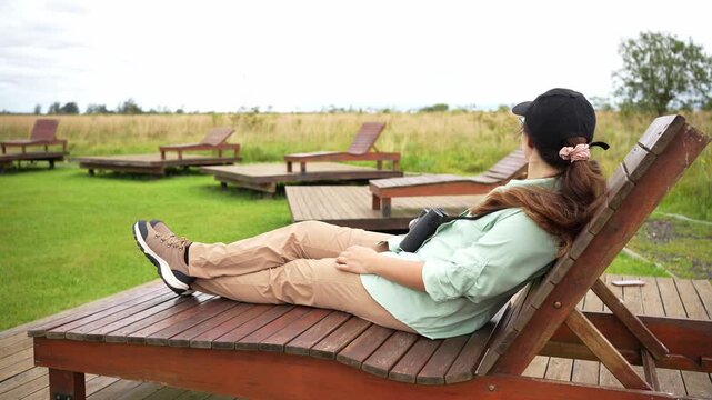 Woman relaxing and birdwatching in a natural park
