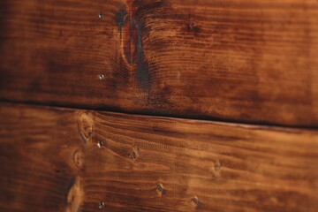 Macro photography of contrast grunge wooden wall with selective focus on weathered natural knotted wood part, wavy lines and small metal screws. Rustic backdrop with copy space. Eco friendly style.