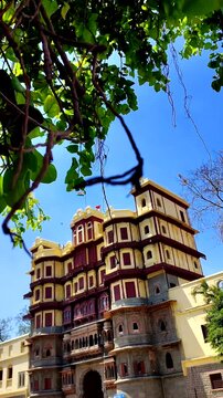 Historic Rajwada Palace Indore India Viewed Through Hanging Banyan Tree Roots Under Clear Blue Summer Sky