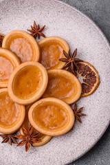 Fototapeta premium Round mini tartlets with citrus or peach jam and crumbly pastry. Mini citrus tarts