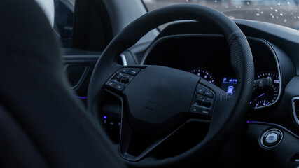 Obraz premium black interior of a modern car. dashboard, leather steering wheel, backlight, radio, screen, air conditioning