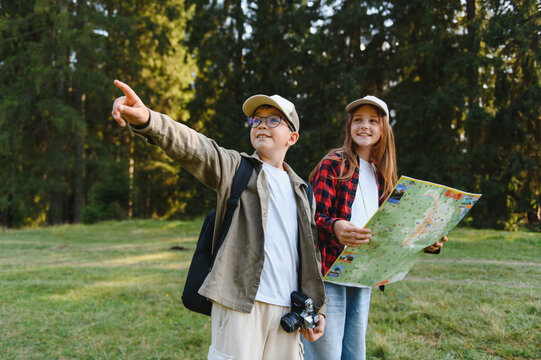 Young hikers exploring nature with map and camera, discovering new trails
