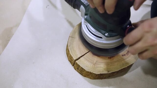 Carpenter sanding a wood with sander