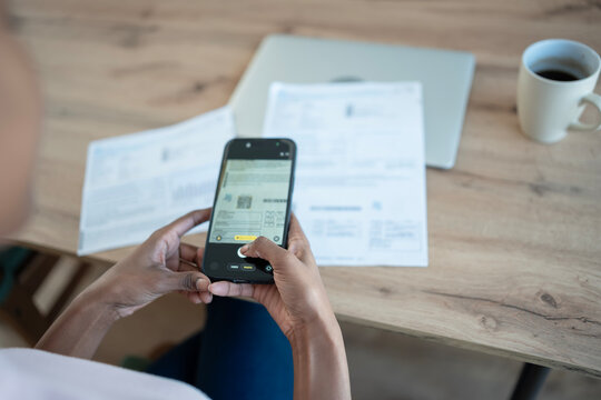 Person scanning qr code on bill with smartphone