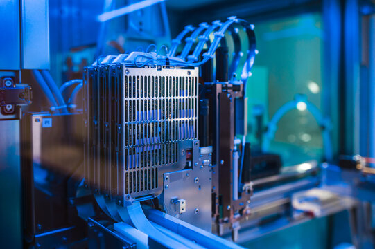 Close Up Robotic Module Loader With Blue LED Illumination, Actuator Arms And Guide Rails Visible, Precise