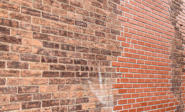 An exterior red brick wall patched with non-matching bricks, nobody