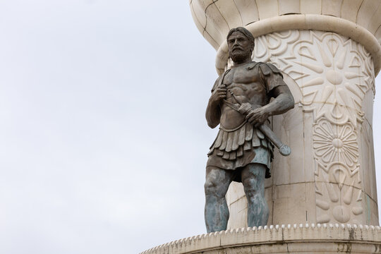Majestic bronze statue of philip ii of macedon in skopje, featuring the king with a raised sword against a clear blue sky, capturing ancient greek legacy.