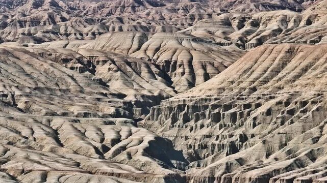 4K footage of textured slopes and sediment layers in a remote desert environment.