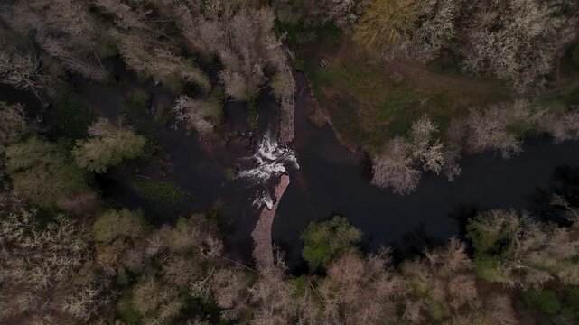 Aerial top down view of river flowing over a weir