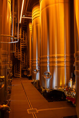 Fototapeta premium Visit of modern underground caves with steel tanks for fermentation and oak barrels for aging og wine, traditional method making champagne sparkling wine in Reims, Champagne, France