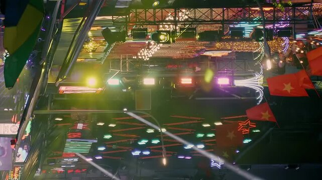 A night street with bars, restaurants, dance clubs, strip bars, casinos and other entertainment venues, where brightly colored spotlights shine and neon signs attract visitors. Vertical video