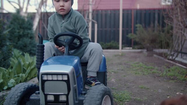 Child honking toy car horn as barking Pomeranian reacts