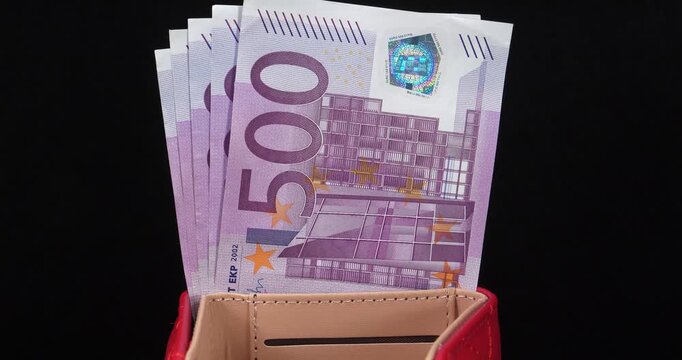 Euro banknotes, EUR. European money. 2500 Euros in five 500 euro banknotes. Cash, finance, savings, wealth. 500 euro banknotes in red wallet