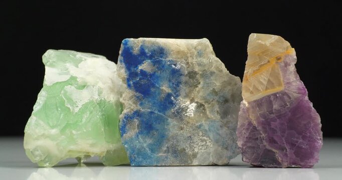 Three natural minerals - blue lapis lazuli, lazurite or Azure spar and two fluorites. Cinema 4K 60fps zoom-in video