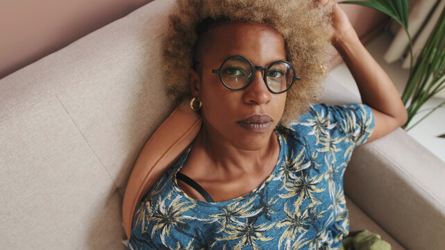 Stylish Woman Relaxing On Couch With Glasses