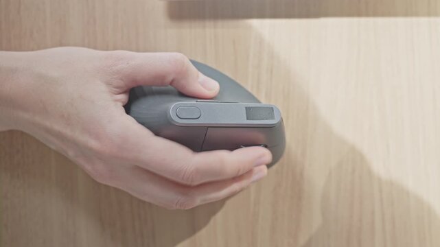 Closeup of woman hand using computer mouse on wooden desk surface. Concept of navigation and computer control