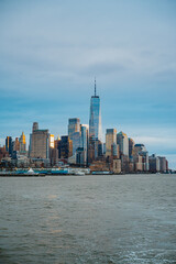 Obraz premium Lower Manhattan skyline with One World Trade Center. Panoramic view of Financial District skyscrapers and One World Trade Center over the Hudson River on overcast day.