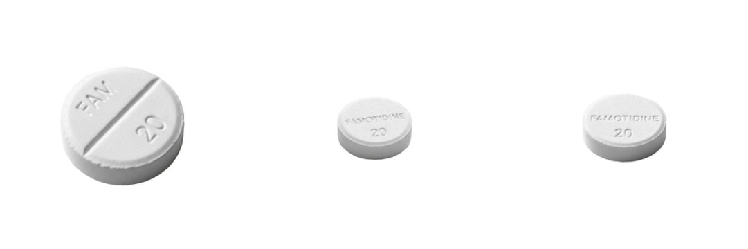 Famotidine tablets H2 receptor antagonist histamine blocker gastric acid reducer medication isolated on white background GERD treatment oral tablets pharma drug for reflux relief