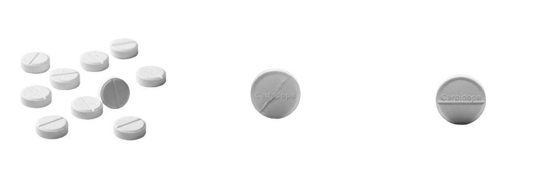 Carbidopa tablets decarboxylase inhibitor medication isolated on white background oral tablets pharma drug used with levodopa for Parkinson disease symptom control and neurological therapy