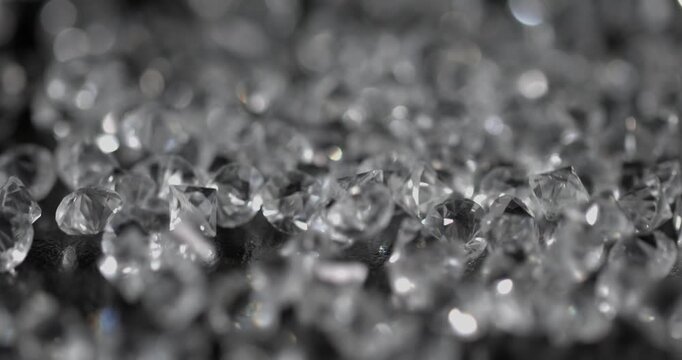 Super slow motion, Macro Shot Of Rough Diamonds Gently Cascading With Shimmering Surfaces Against Dark