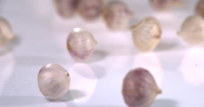 Super slow motion, Soft Cascade Of Garlic Bulbs Highlighted By Gentle Reflections And Delicate Shadow Patterns