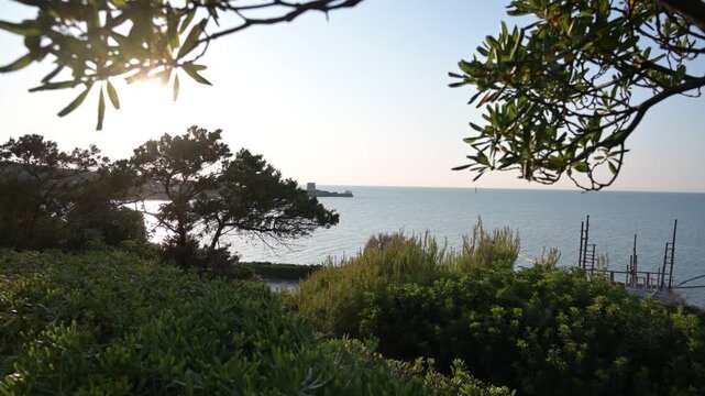 antica torre saracena vicino ad un piccolo trabucco in legno sulla costa del gargano, in puglia