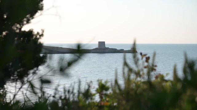 antica torre saracena vicino ad un piccolo trabucco in legno sulla costa del gargano, in puglia