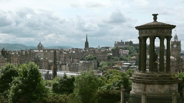 Edinburgh skyline with historic architecture, Calton Hill monument and cityscape under cloudy sky, showing iconic Scottish urban landscape.