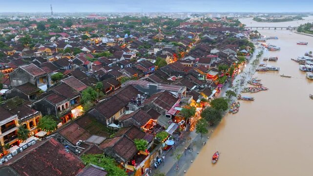 Aerial view of tourists and locals enjoying the evening lights along the Thu Bon River in the UNESCO World Heritage city of Hoi An, Vietnam.