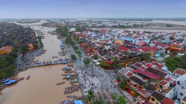 Aerial view of tourists and locals enjoying the evening in the UNESCO World Heritage city of Hoi An, Vietnam. People are walking, boating, and enjoying the night life.