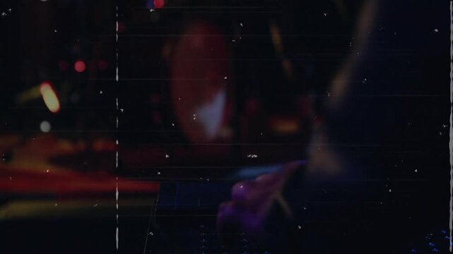 Hands cueing synth riff to start, camera pulling back showing singer, band performing under grain