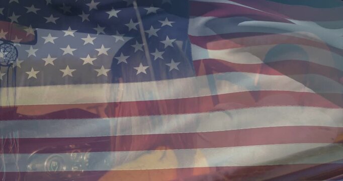 Male musician adjusting then strumming guitar practicing, US flag overlay rippling over performer