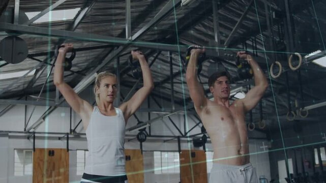 Pair pressing KBs from rack to overhead, cycling to final overhead, grid showing reps for fitness