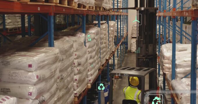 Reacting to sensor overlays, driver in hi-vis hard hat aligning forks to lift pallet in warehouse