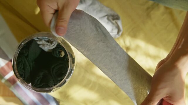 Folded socks being stored inside a plastic container. Organizing socks while resting at home on the weekend.