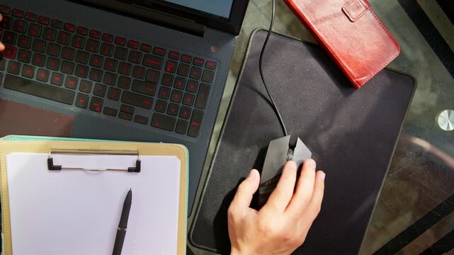 Hand operating a laptop mouse. Top-down view of working on a laptop.